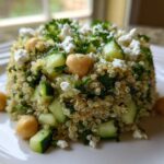 A molded serving of the Jennifer Aniston Salad featuring quinoa, chopped cucumber, chickpeas, and crumbled feta cheese.