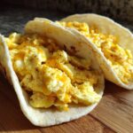 Two soft flour tortillas filled with fluffy scrambled eggs and melted cheese, perfect Potato Egg Cheese Breakfast Tacos.