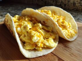 Two soft flour tortillas filled with fluffy scrambled eggs and melted cheese, perfect Potato Egg Cheese Breakfast Tacos.