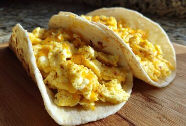 Two soft flour tortillas filled with fluffy scrambled eggs and melted cheese, perfect Potato Egg Cheese Breakfast Tacos.