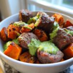 Close-up of Steak and Sweet Potato Bowls topped with bright green avocado-cilantro drizzle.